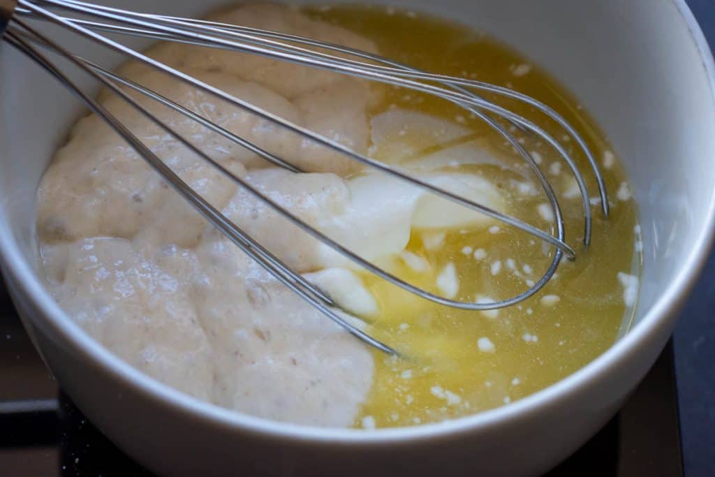 Mixing sourdough discard with pineapple juice and yogurt.