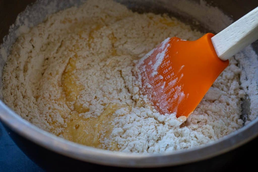 Folding dry ingredients with the wt ingredients to form a sourdough cake batter.
