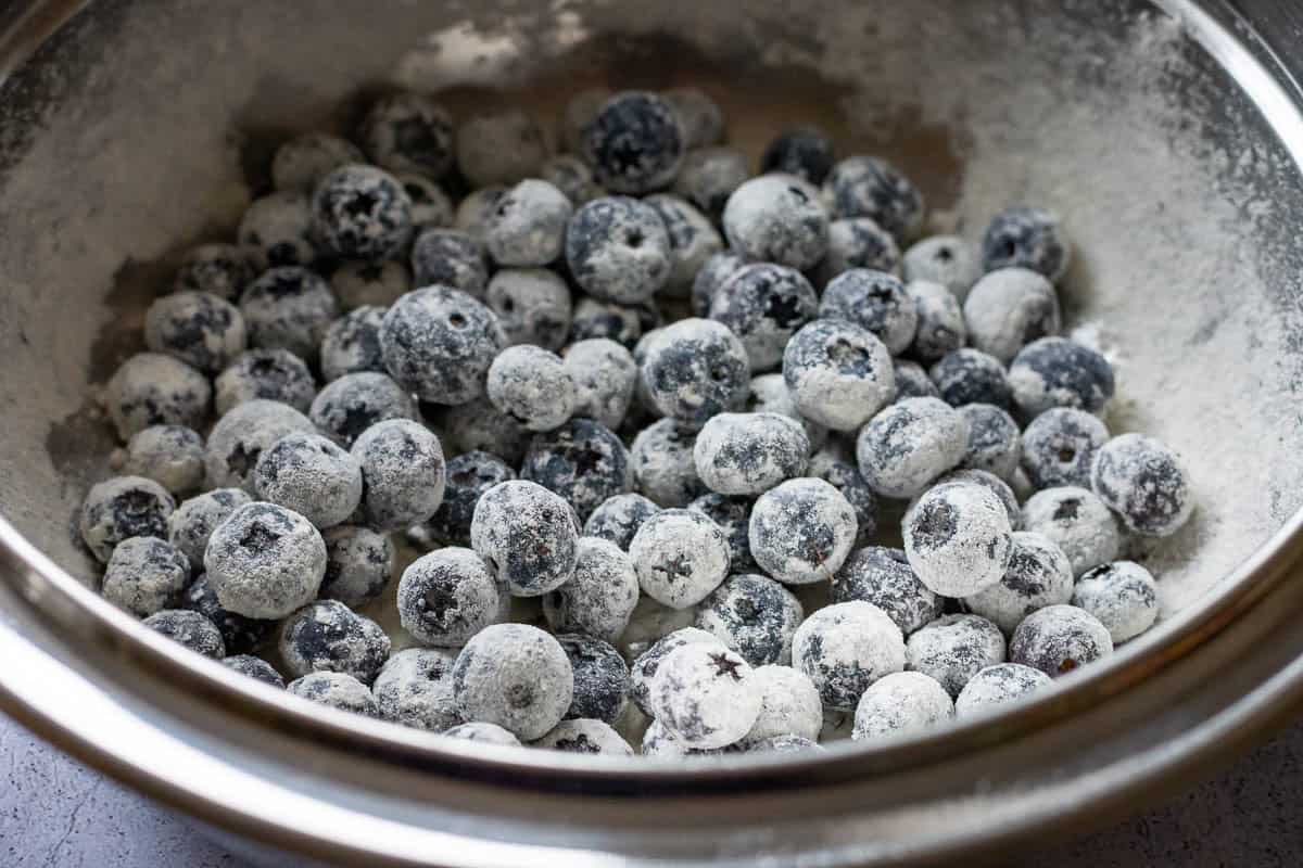 Blueberries mixed with flour in a large bowl.