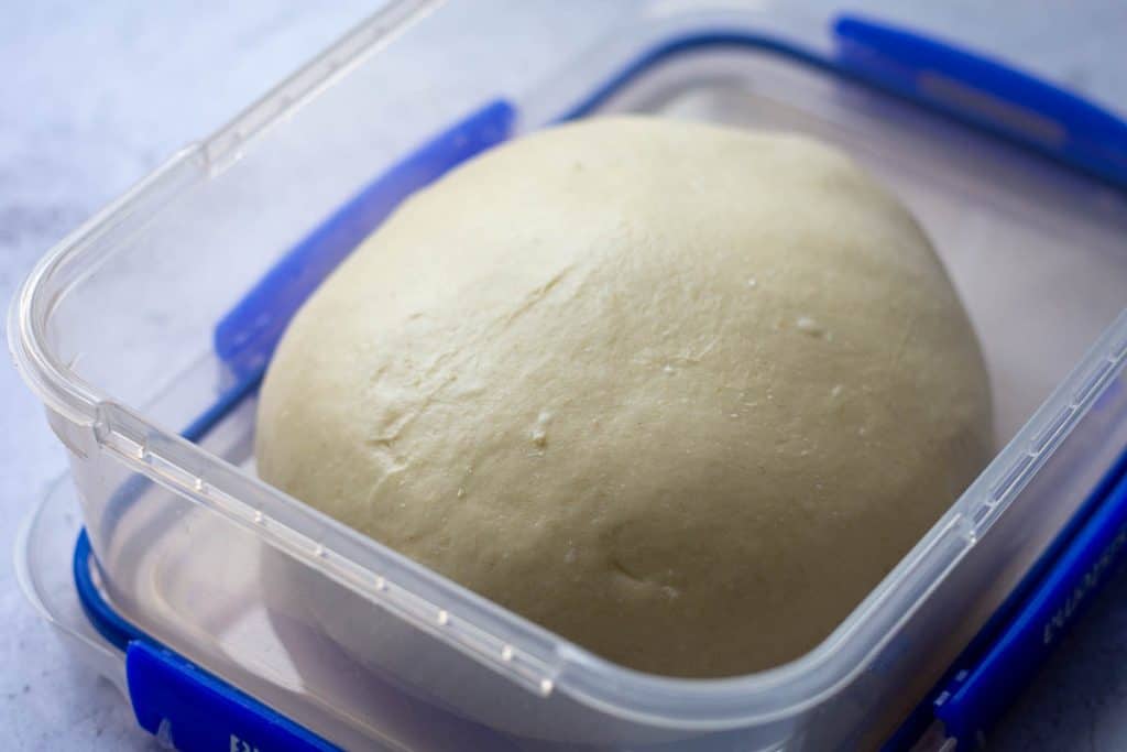 enriched sourdough for the savory sourdough rolls at the beginning of bulk fermentatio in a container.