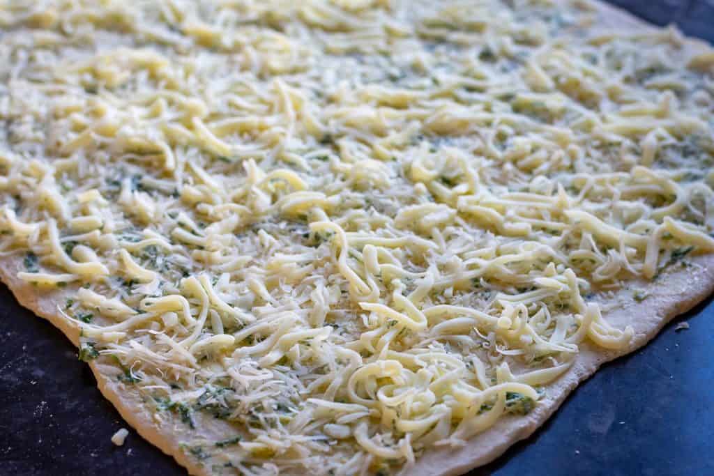 Grated cheese scaterred on top of the garlic butter covered sourdough.