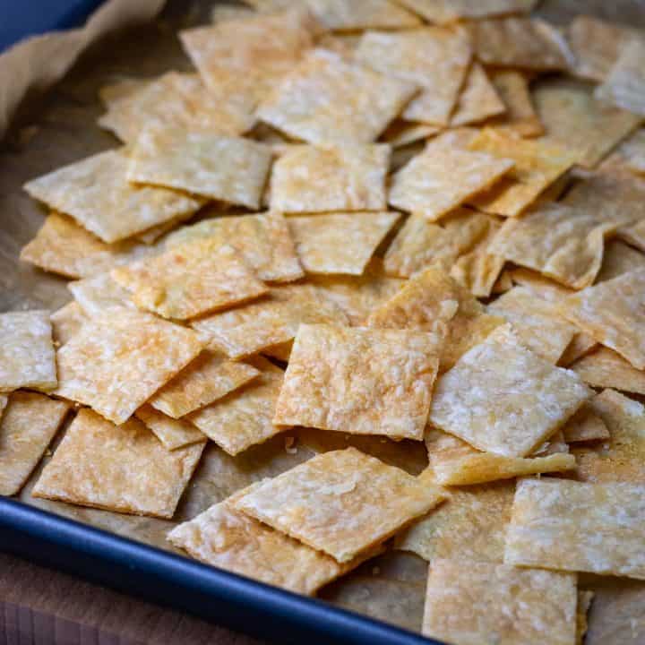A mound of sourdough discard parmesan crackrs on a baking sheet lined with parchment paper.