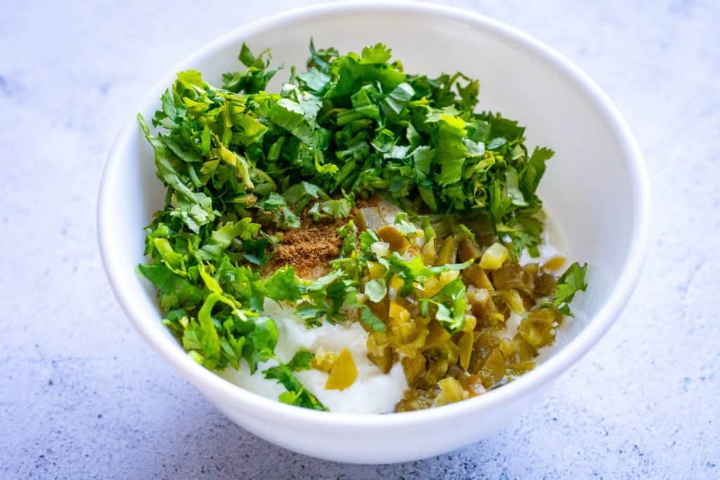 ingredeinrs for jalapeno sour cream sauce in a small bowl.