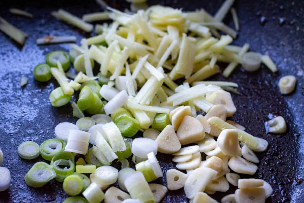 Spring onion, ginger and garlic in a frying pan.