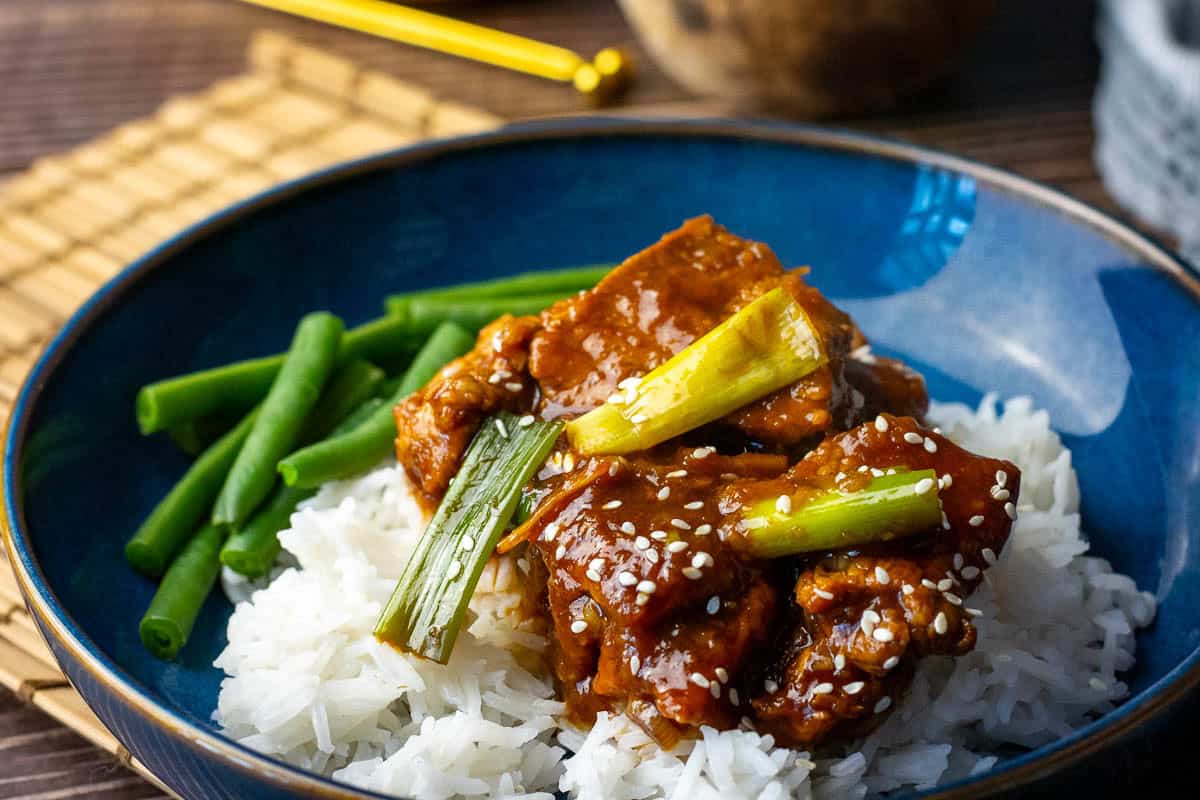 Sweet and sticky slow cooked Mongolian pork served on a bed of rice with green beans.