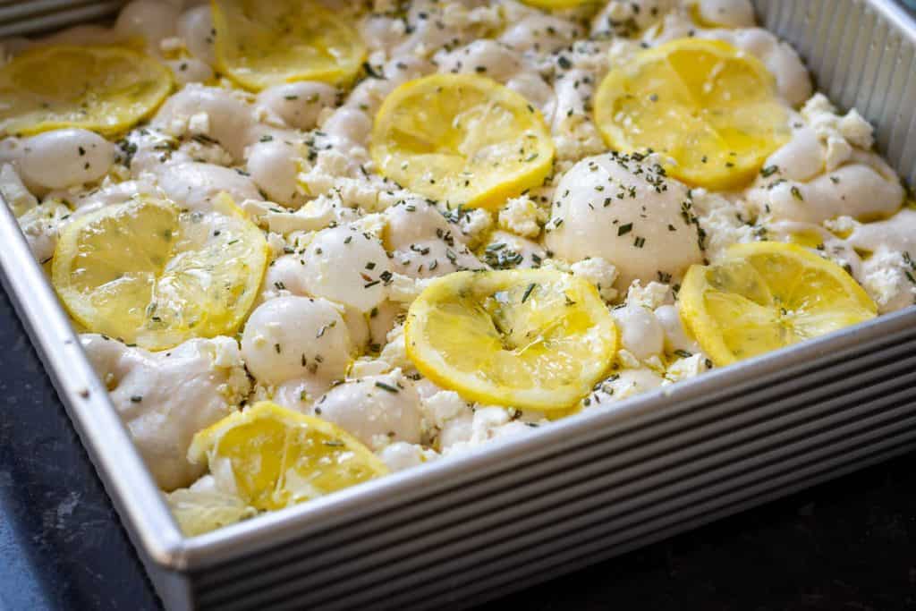 Thin lemon slices arranged on top of the sourdough focaccia.