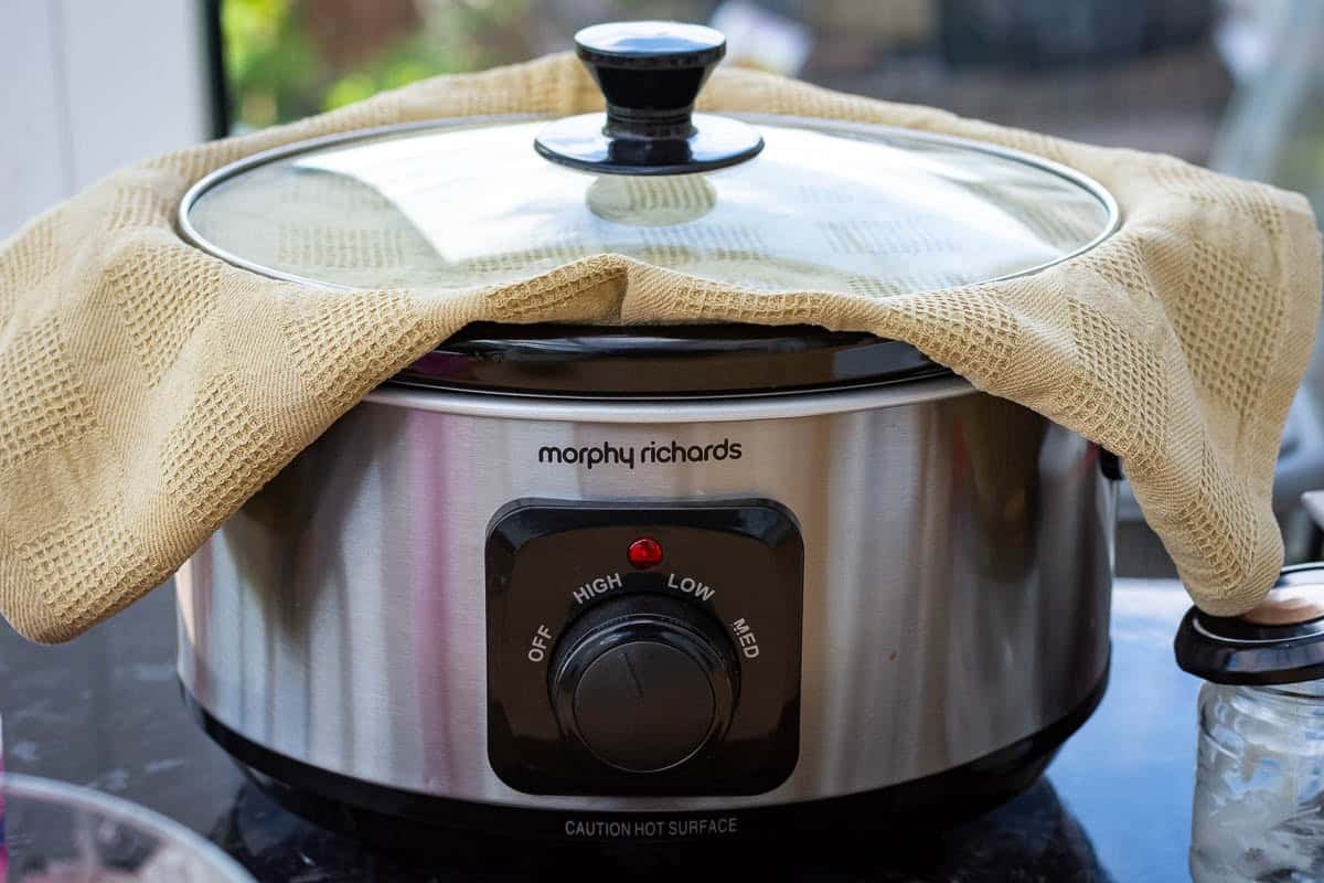 Clean kitchen towel in between slow cooker and the lid.