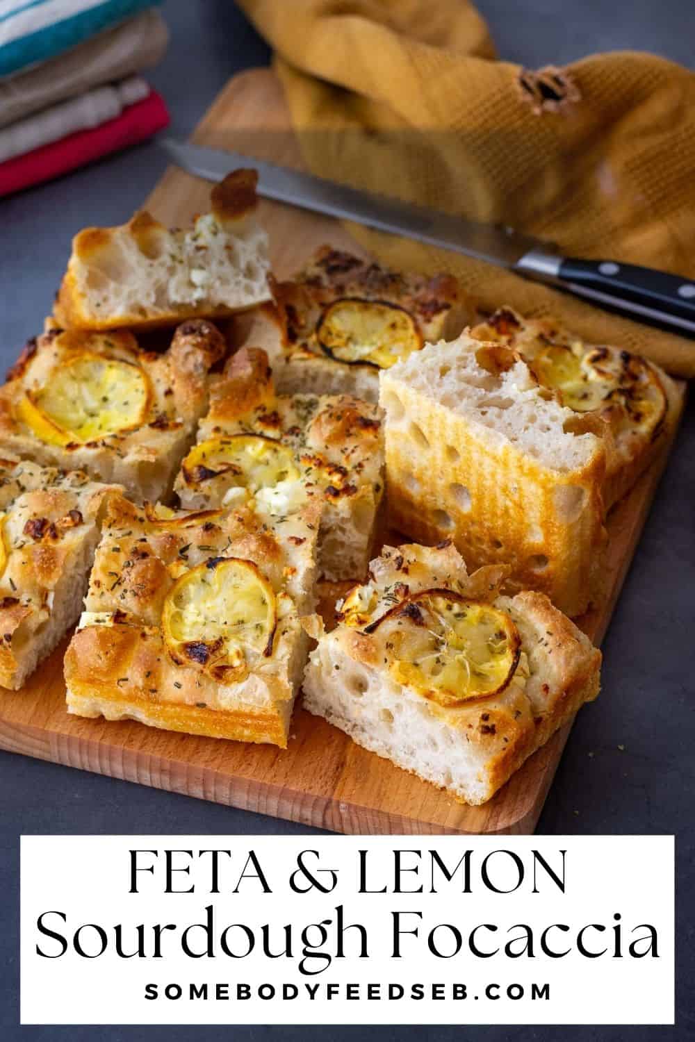 Lemon and feta sourdough focaccia cut into squares on a wooden board. Pin for Pinterest.