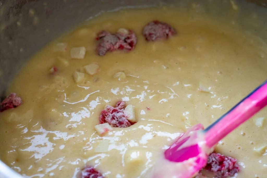 Carefully mixing the sourdough muffin batter to avoid braking up raspberries.