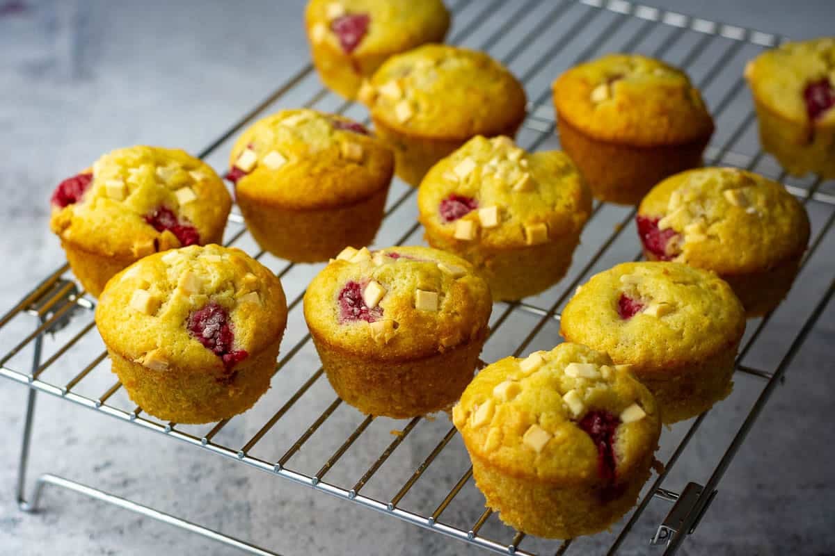 Sourdough raspberry white chocolate cupcakes cooling on a wire rack.