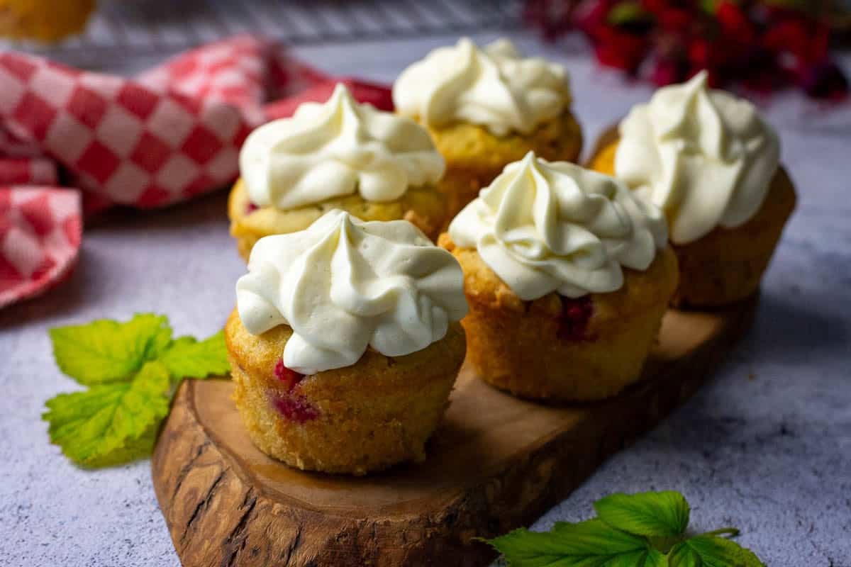 Sourdough Raspberry Cupcakes with white chocolate cream cheese icing piped on top.