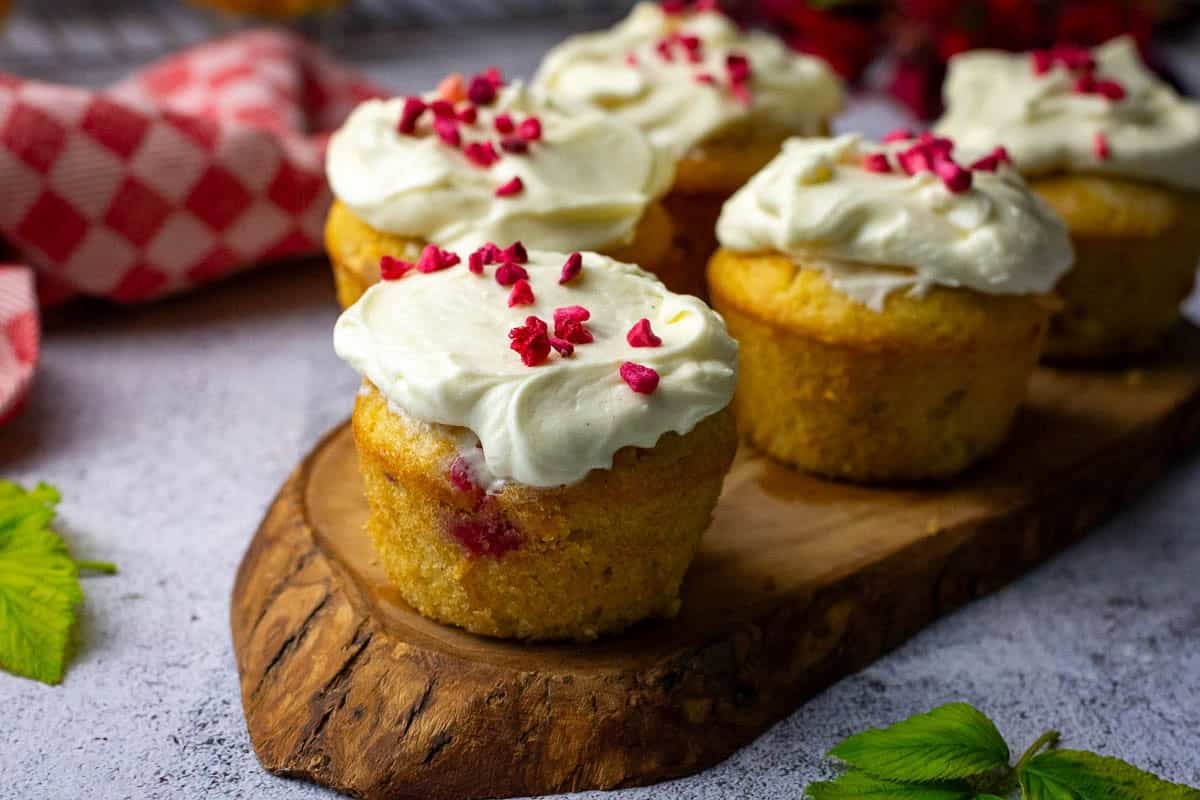 Sourdough Raspberry Cupcakes with icing spread on top and topped with freeze fried raspberries.