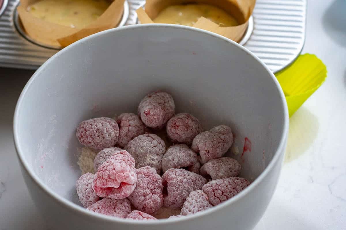 Raspberries tossed in flour in a white bowl.