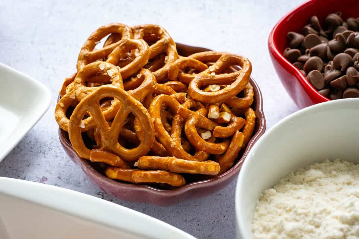 Salted pretzels in a small bowl on a light kitchen worktop.