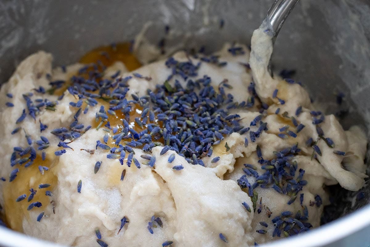 Honey and lavender on sourdough dough in a stand mixer fitted with a dough hook attachment.
