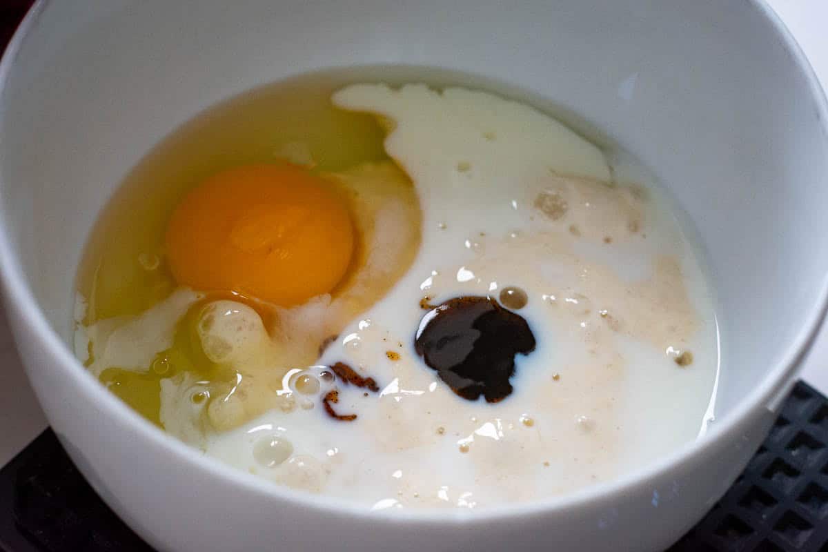 Wet ingredients for sourdough discard scones in a white bowl.