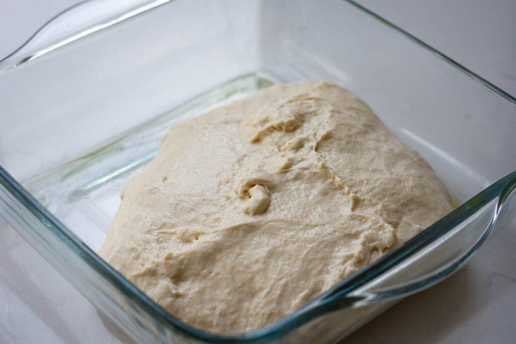 Sourdough focaccia dough in a glass dish right after mixing.
