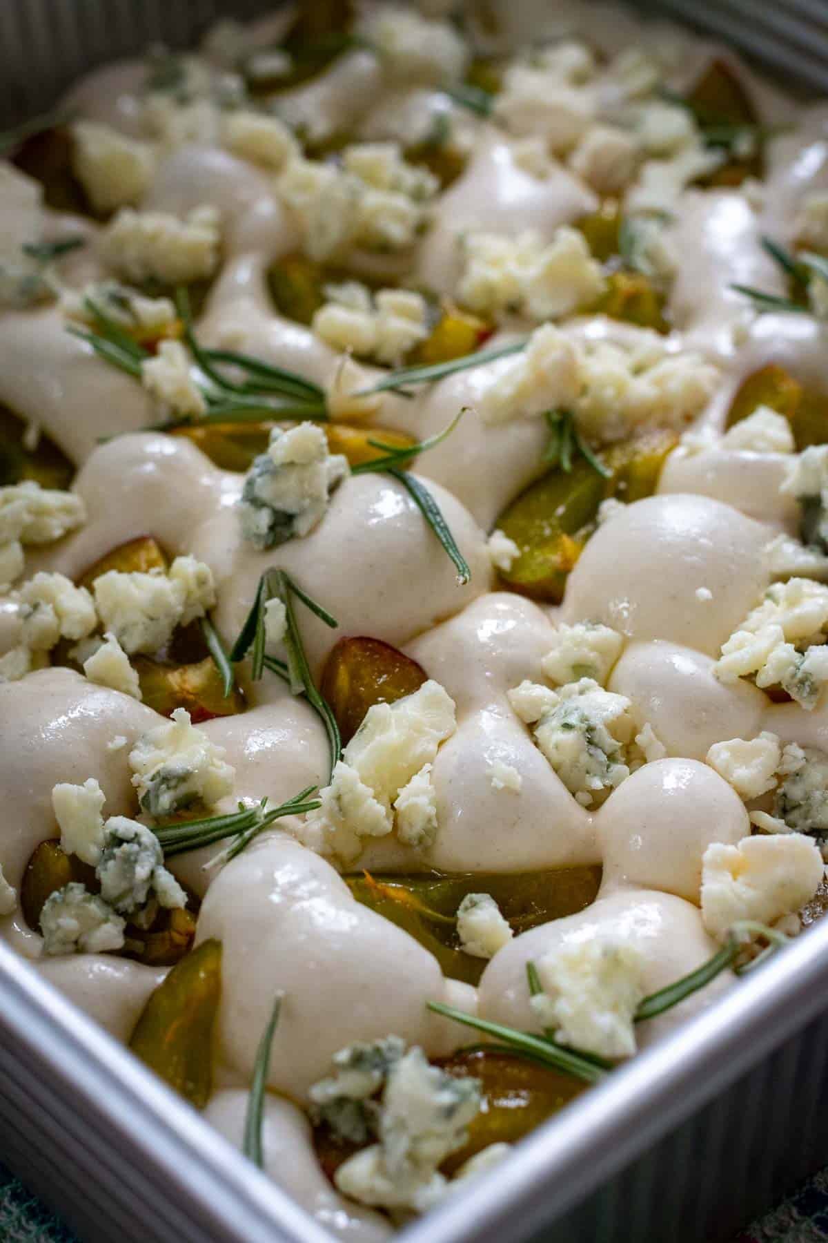 Sourdough focaccia dough topped with plums, gorgonzola and rosemary.