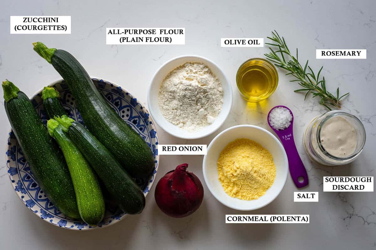 Labelled ingredients for sourdough zucchini scarpaccia. on a light kitchen worktop.