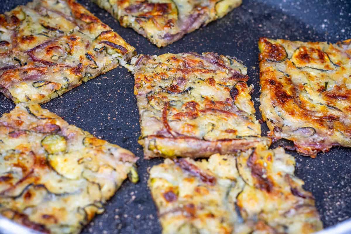 Sourdoug hscarcaccia squares being reheated in a large frying pan.