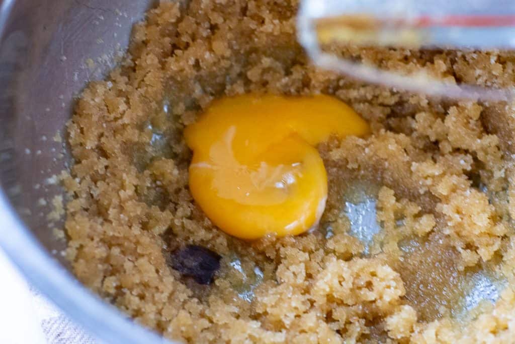 An egg yolk and vanilla bean paste added to the sugar and butter mixture.