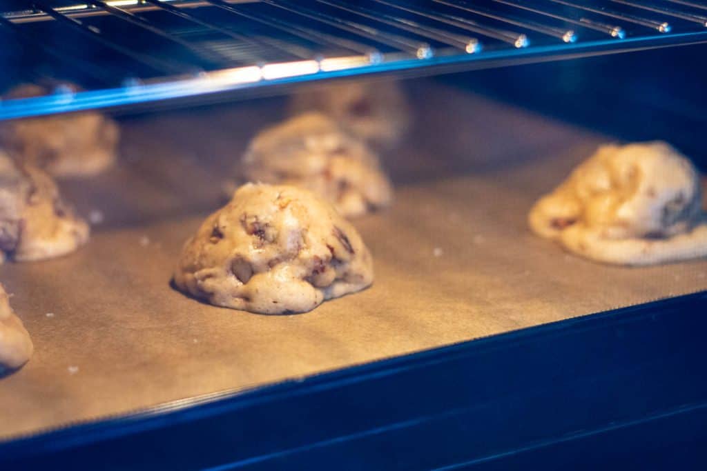 Butter pecan sourdough cookie sin the oven spreading slowly.