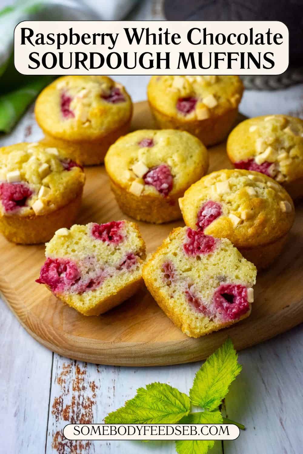 Raspberry and White chocolate sourdough discard muffins on a wooden board with one cut in half. Pin for Pinterest.