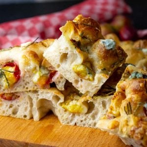 Plum and Gorgonzola Sourdough Focaccia squares on a wooden board.