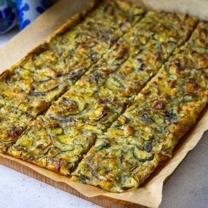 Sourdough Scarpaccia cut into squares on a wooden board.
