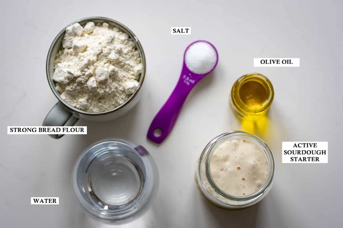 Ingredients for sourdough focaccia muffin dough on a light kitchen worktop.