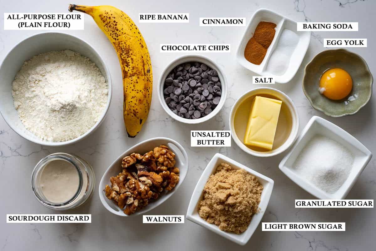 Labelled ingredients for sourdough banana bread cookies on a light quartz kitchen worktop.