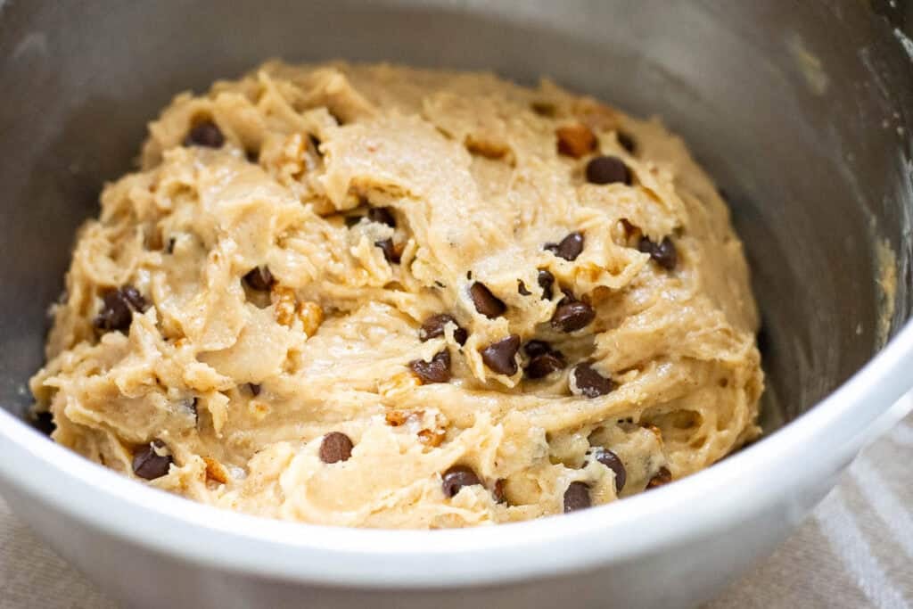 Chilled sourdough banana bread cookie dough in a large metal mixing bowl.