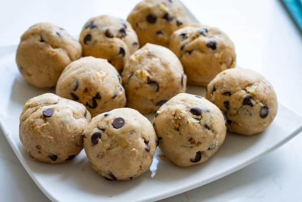 10 sourdough banana bread cookie dough balls on a plate ready for freezing.