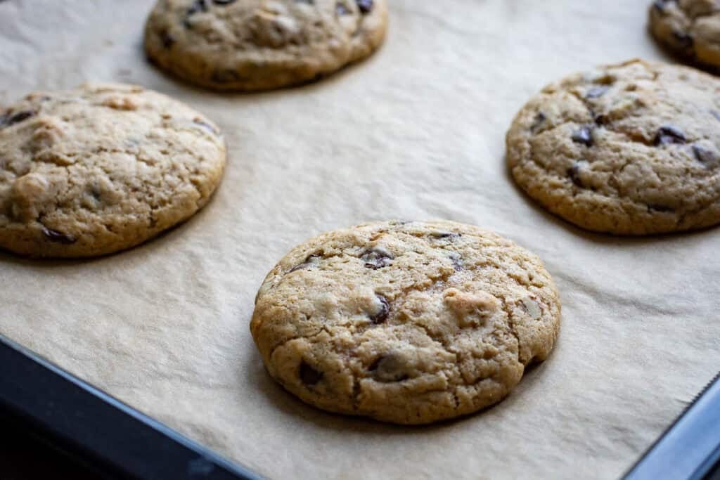 Baked sourdough discard banana cookies on a parchment paper lined baking sheet.