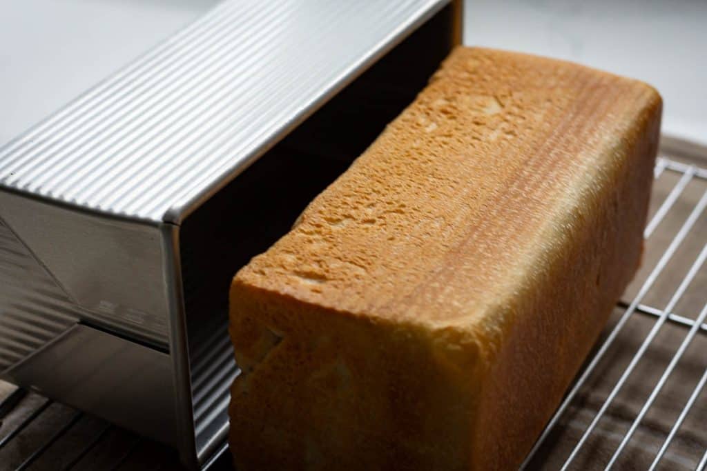 Sourdough pullman loaf removed from the pan onto a wire rack for cooling.