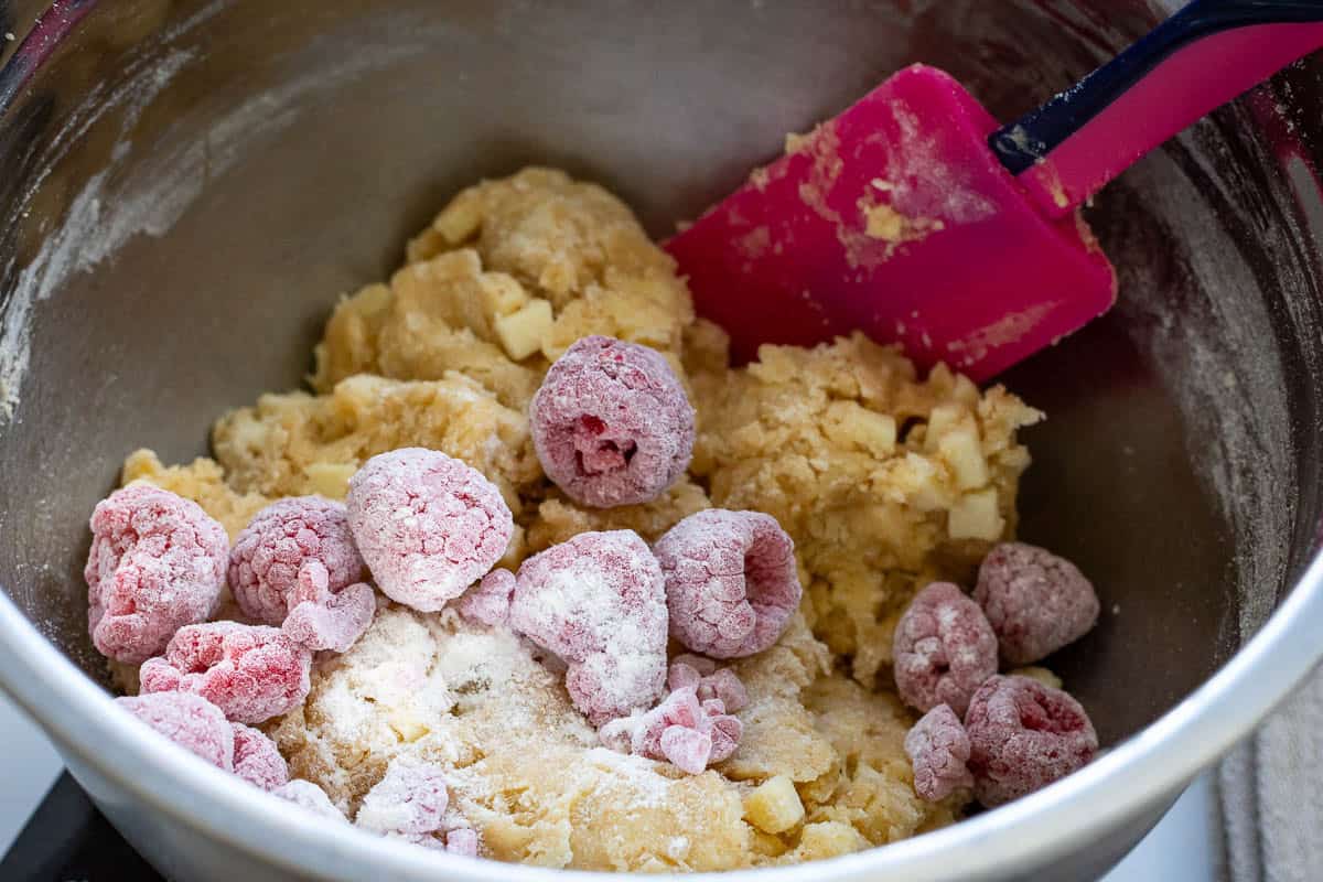 Flour coated raspberries being mixed into the sourdough cookie dough.
