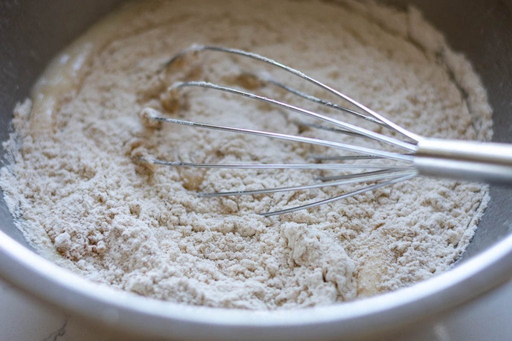 Combining wet and dry ingredients using a balloon whisk.