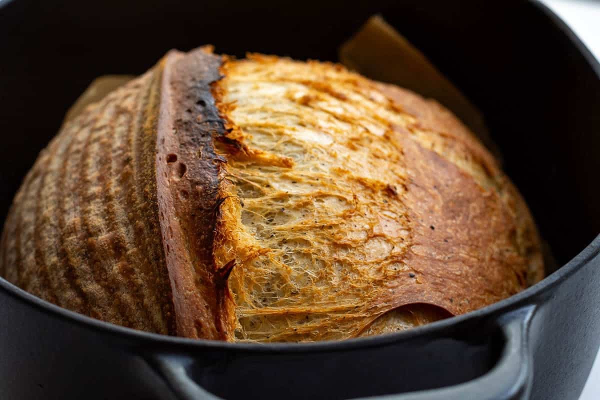 Deep golden brown London Fog Sourdough Bread in a Dutch oven.