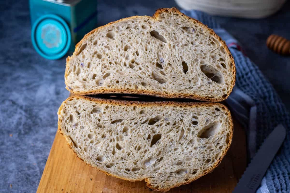 Earl Grey Sourdough Bread cut in half on a wooden board.