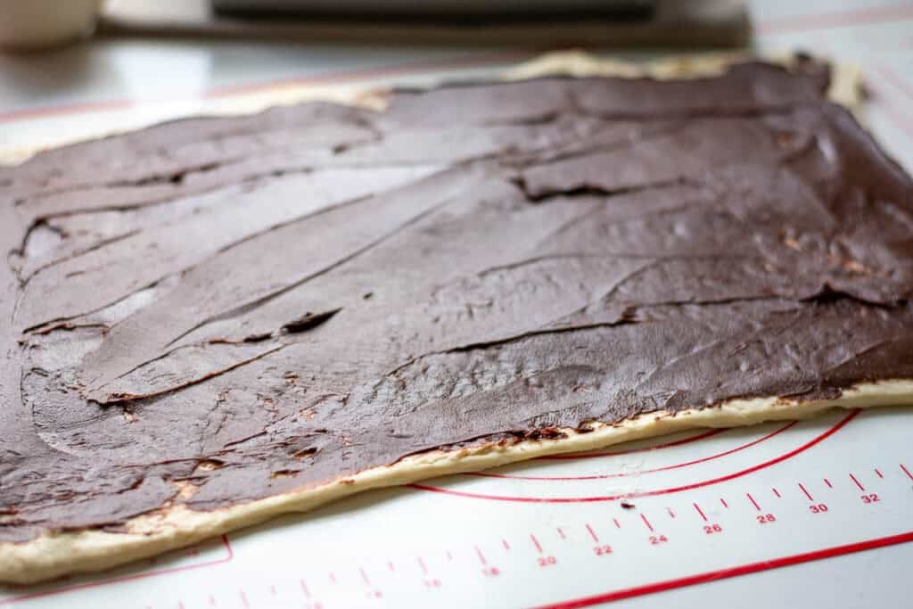Chocolate filling spread across the rolled-out sourdough.