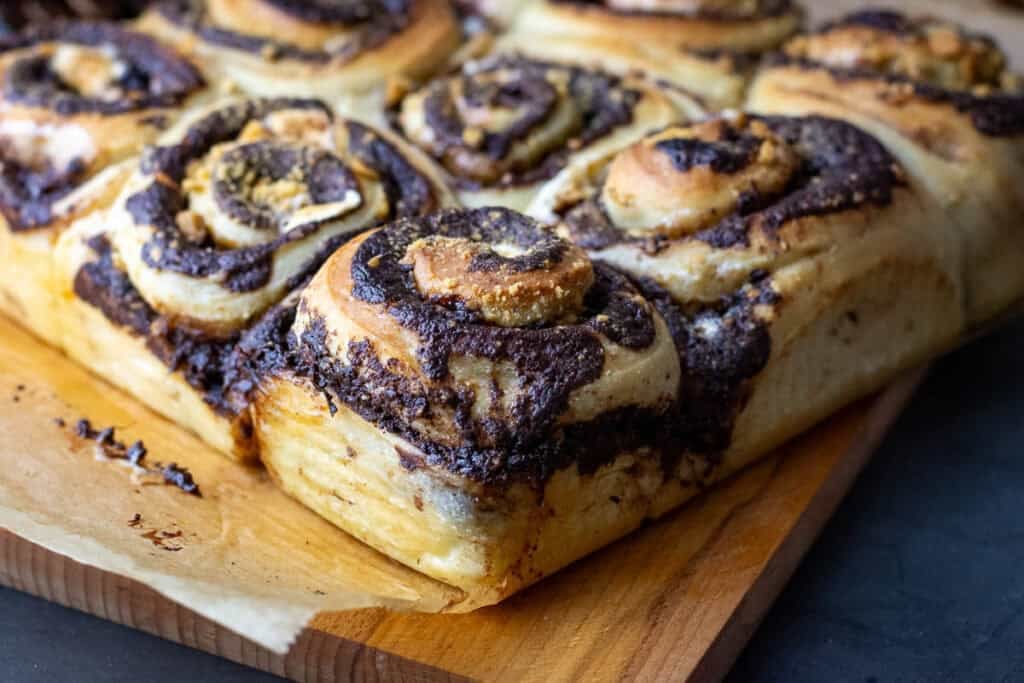 Sourdough sm'ores rolls on a piece of parchment paper on a wooden board.