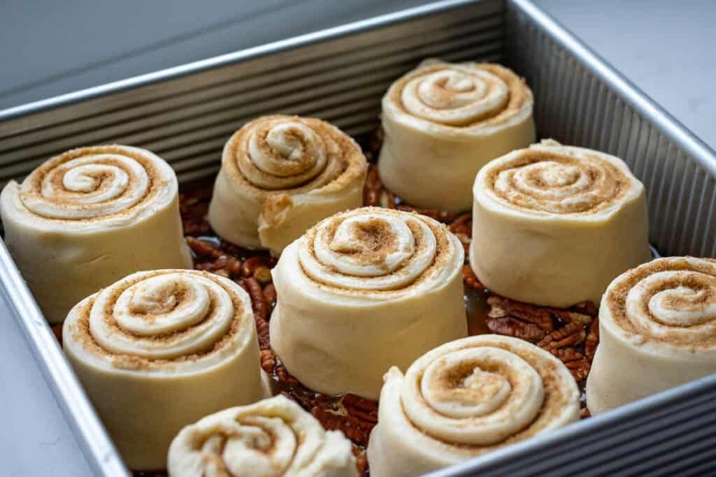Sourdough sticky buns arranged on the maple pecan caramel.
