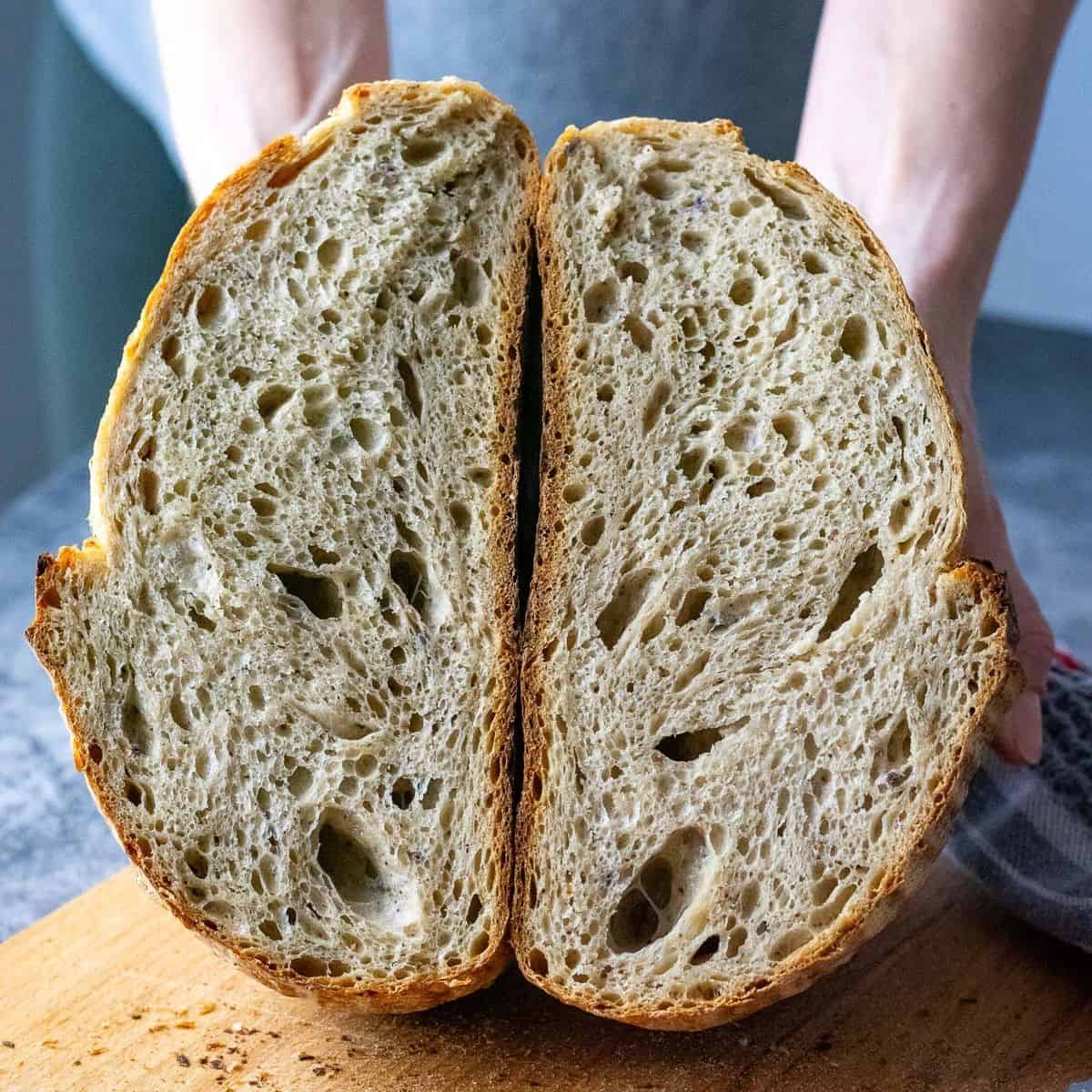 Earl Grey Sourdough Bread cut in half held in hands.