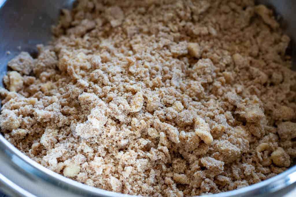 Mixed streusel topping in a large metal bowl with some larger clumps.