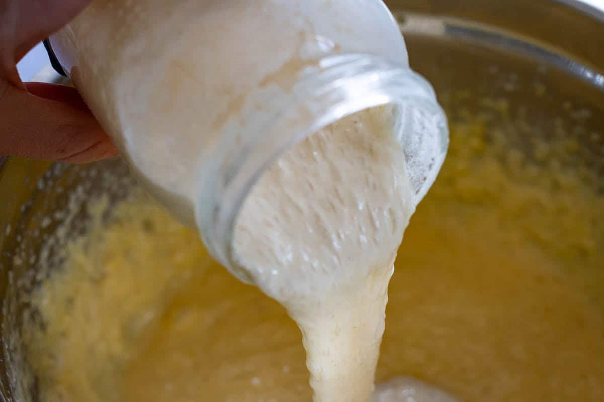 Sourdough discard being poured into the cake batter.