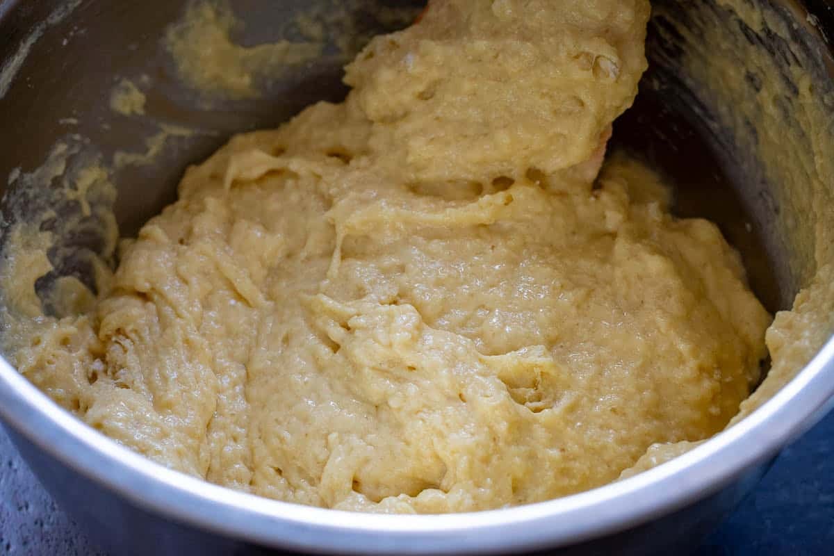 Thick sourdough cake batter in a metal mixing bowl.