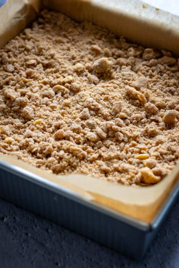 Streusel topping scaterred on top of sourdough coffee cake.