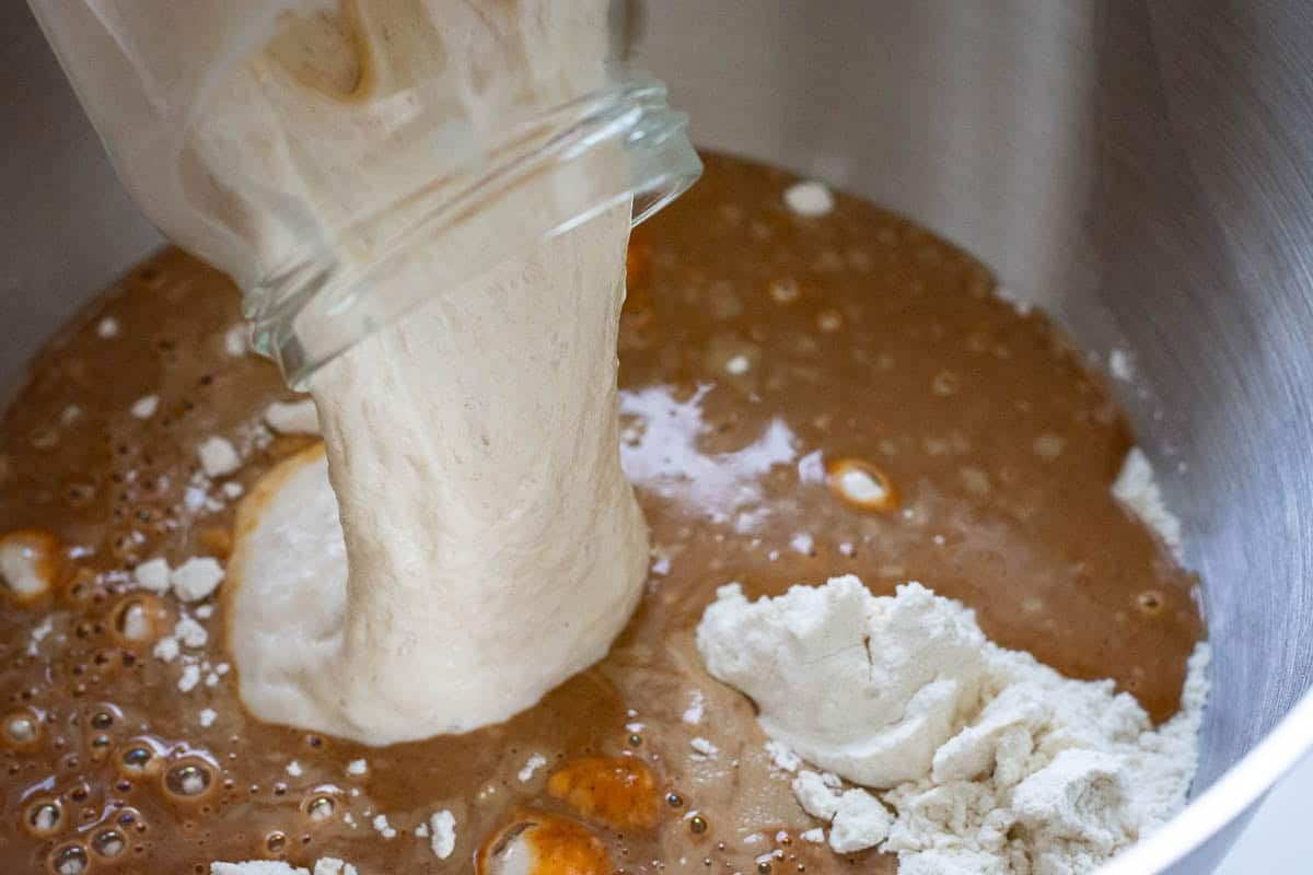 Pouring sourdough starter into the pupkin spice latte sourdough bread mixture.
