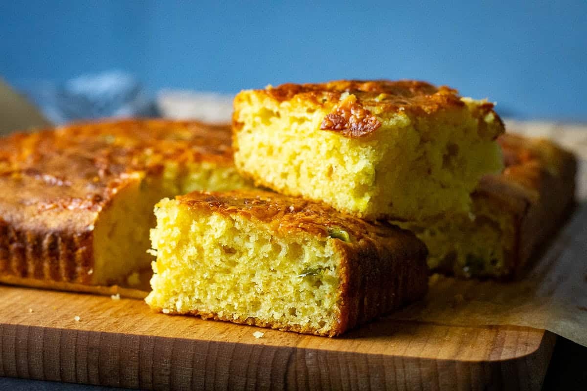 Two squares of jalapeno cheddar sourdough cornbread stacked on top of each other.