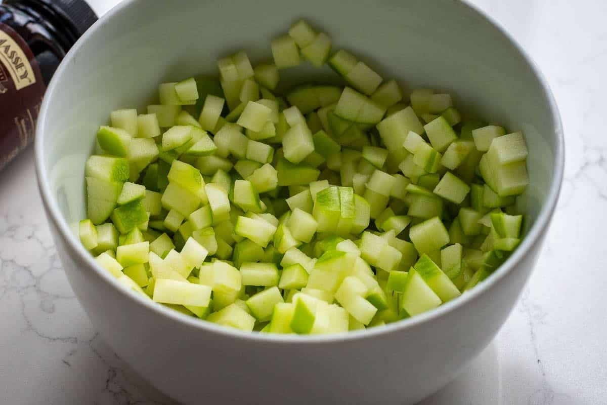 Cubed Granny Smith Apples in a white bowl.